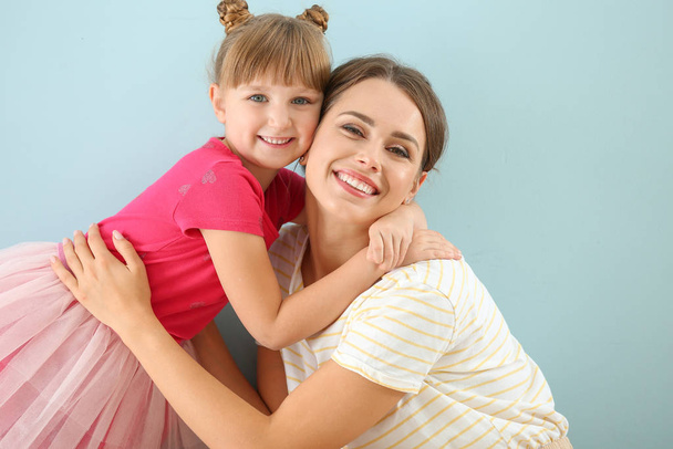 Retrato de madre e hija feliz sobre fondo de color
 - Foto, imagen