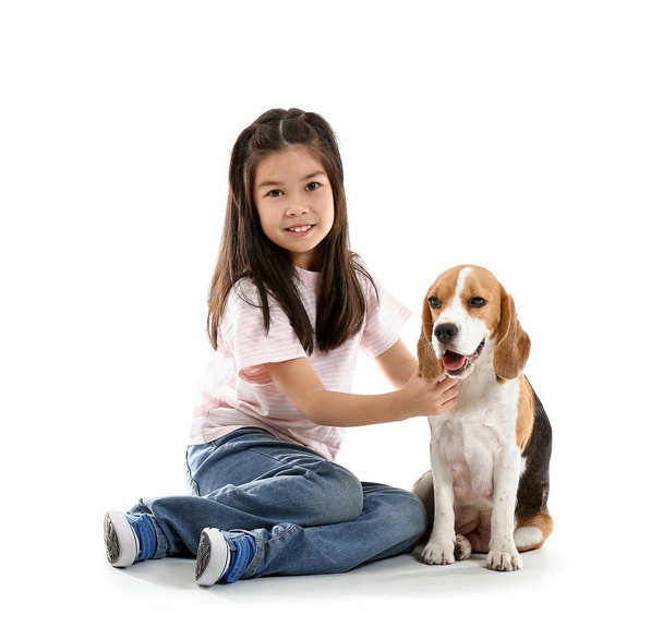 kleine asiatische Mädchen mit niedlichen Beagle Hund auf weißem Hintergrund - Foto, Bild