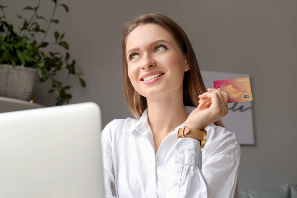 Młoda kobieta z karty kredytowej i zakupów komputerowych online w domu - Zdjęcie, obraz