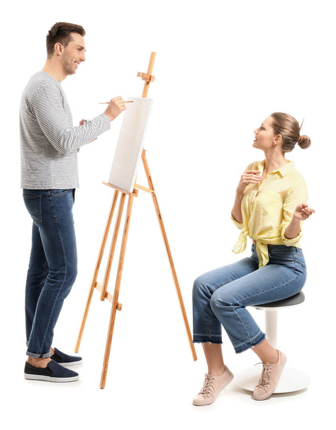 Молодая женщина позирует для художника на белом фоне
 - Фото, изображение
