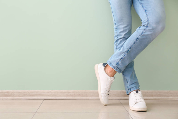 Young man in stylish shoes near color wall - Photo, image