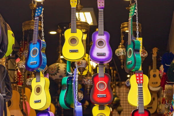 Colorful guitars hang inside the shop - Foto, Imagem