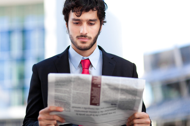 Handsome man reading a newspaper - Фото, изображение