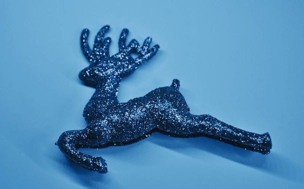 Sprankelende kerst herten op glitter papier textuur in blauwe kleur. - Foto, afbeelding
