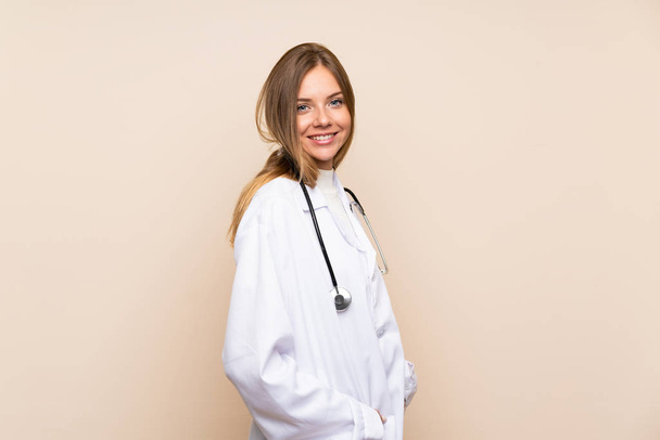 Young blonde woman over isolated background with doctor gown - Fotografie, Obrázek