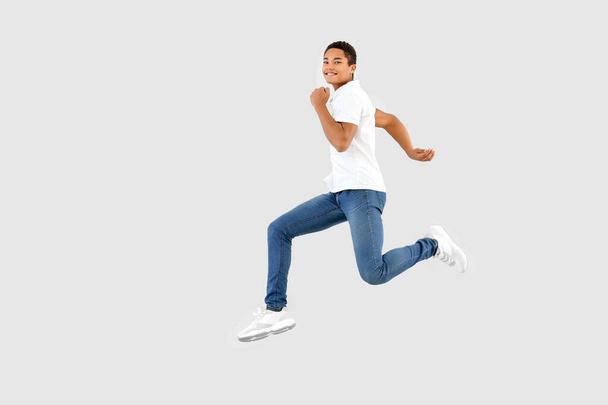 Jumping African-American teenager boy on white background - Photo, Image