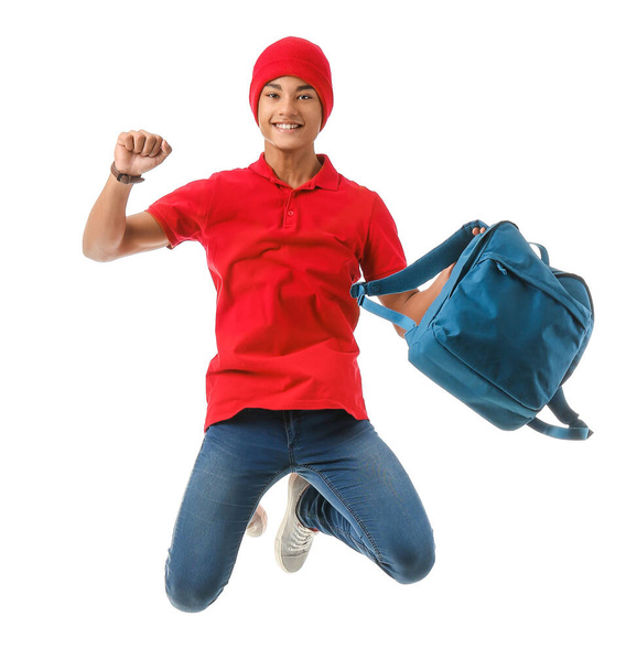 Springen afrikanisch-amerikanische Teenager Junge mit Rucksack auf weißem Hintergrund - Foto, Bild