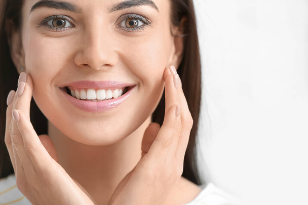 Mulher bonita com dentes saudáveis no fundo claro
 - Foto, Imagem