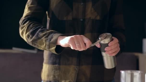 Hands holding coffee grinder and winding its handle while grinding coffee beans. - Imágenes, Vídeo