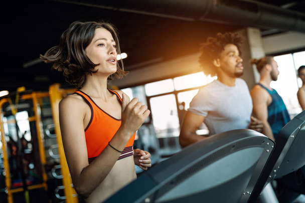 Picture of fit people running on treadmill in gym - Foto, immagini