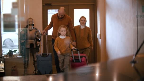 A happy family in similar clothes entering the luxury hotel - Filmati, video