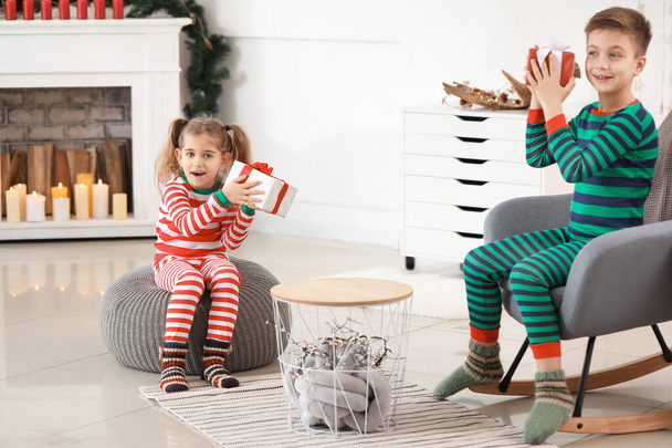 Cute little children with Christmas gifts at home - Photo, Image