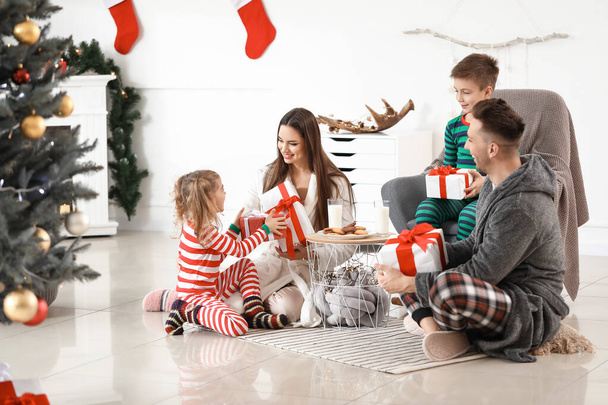 Família feliz com presentes em casa na véspera de Natal
 - Foto, Imagem