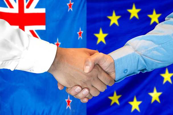 Handshake on New Zealand and European Union flag background. - Photo, Image