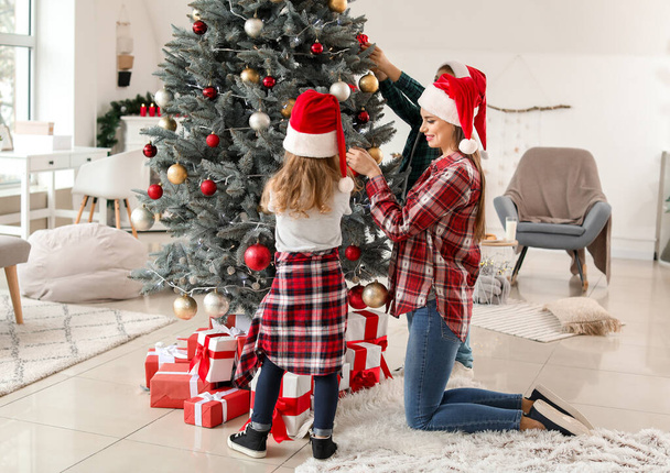 glückliche Familie schmückt Weihnachtsbaum zu Hause - Foto, Bild