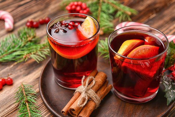 Glasses of tasty mulled wine on wooden background - Foto, afbeelding