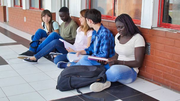 Diversidade Estudantes Conceito de Felicidade Amigos. Cinco colegas sentados no corredor da escola. - Foto, Imagem