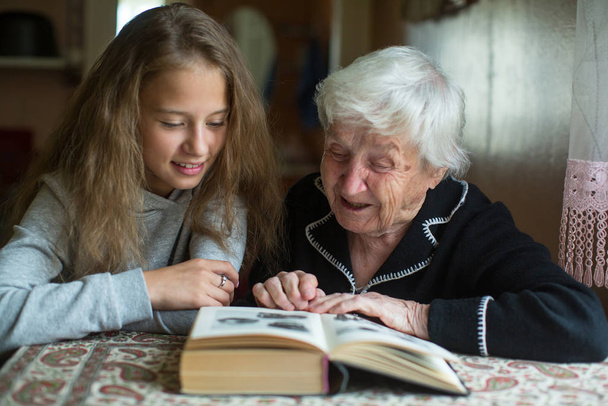 Grand-mère avec une petite fille - petite-fille lisant un livre
.  - Photo, image