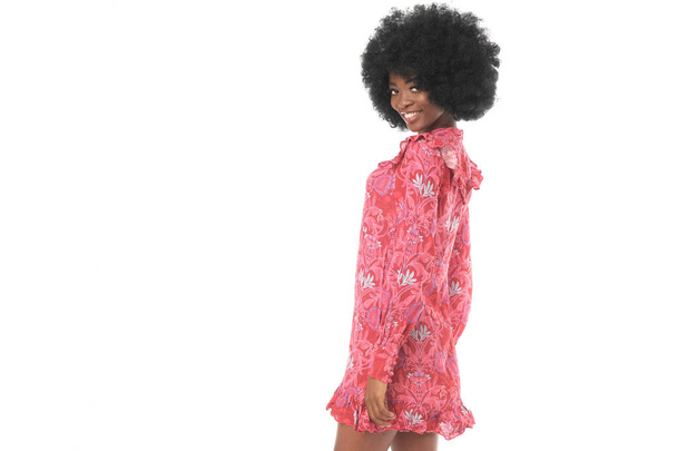 ピンクのミニドレスで美しいアフロアメリカのモデルは、白の背景に隔離. - 写真・画像