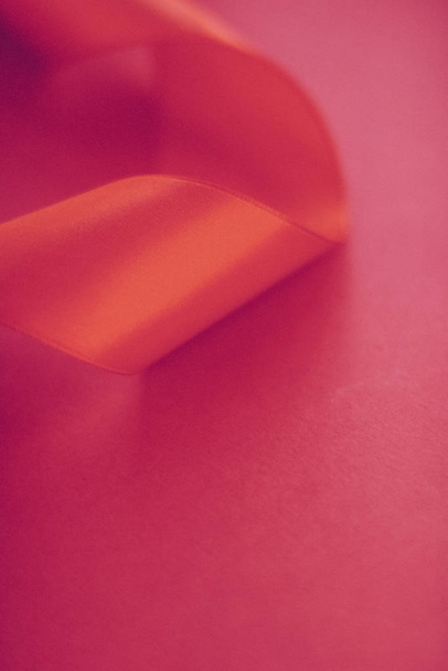abstrakte lockige Seidenschleife auf rosa Hintergrund, exklusiver Luxus  - Foto, Bild