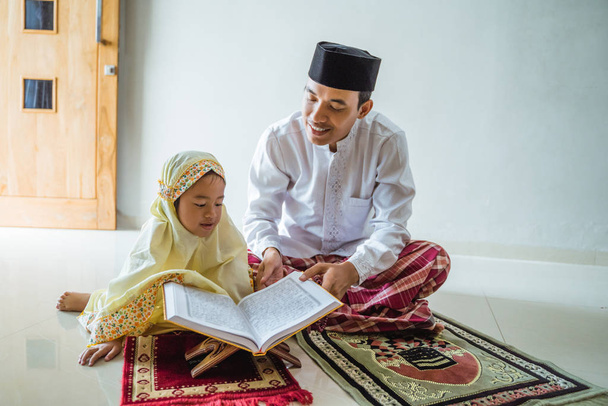 father and kid read qoran togethe - Фото, зображення