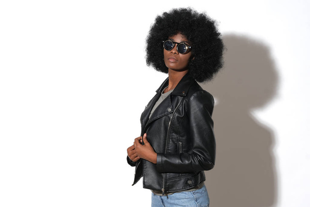 Sexy afro meisje in zwart leer, rotsachtige jas. - Foto, afbeelding