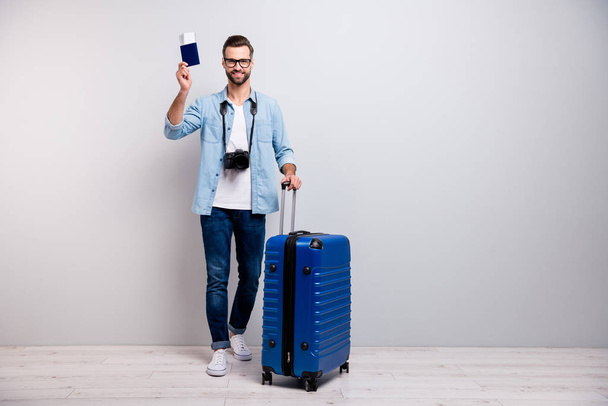 Full length photo of handsome guy big tourist bag show airport tickets documents traveler professional photographer wear specs denim outfit isolated grey color background - Fotoğraf, Görsel