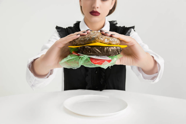 We are what we eat. Womans eating plastic food, eco concept - Fotoğraf, Görsel