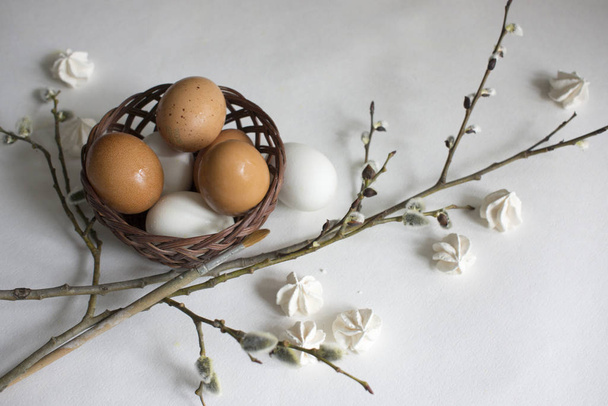 Φωλιά με λευκά και καφέ αυγά κότας και αυγά ορτυκιού, κλαδιά ιτιάς - Φωτογραφία, εικόνα