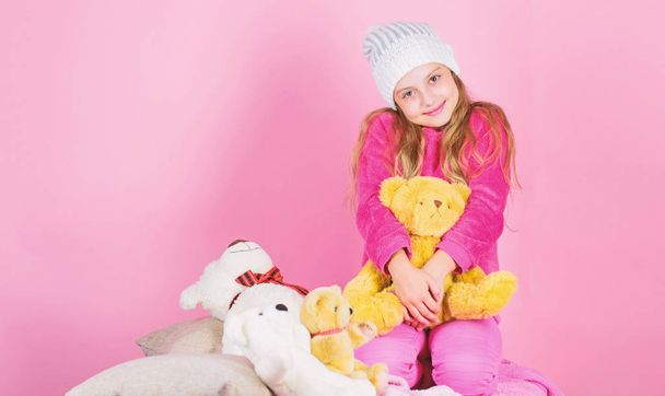 Unique attachments to stuffed animals. Kid little girl play with soft toy teddy bear pink background. Child small girl playful hold teddy bear plush toy. Teddy bears improve psychological wellbeing - Photo, image