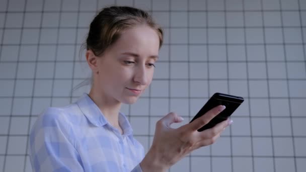 Γυναίκα κρατώντας smartphone και χρησιμοποιώντας λειτουργία αναγνώρισης φωνής - Πλάνα, βίντεο