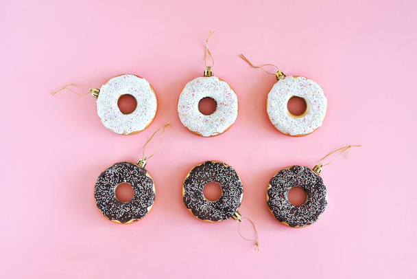 Christmas decoration donuts on a pastel pink background. New Year and Christmas creative concept. Top view, flat lay. - Foto, imagen