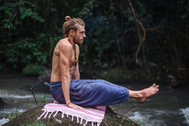 Yoga beoefening en meditatie in de natuur. Man beoefenen in de buurt van de rivier - Foto, afbeelding