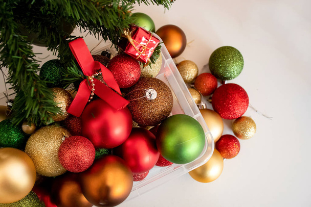 Χριστουγεννιάτικες μπάλες σε ένα πλαστικό διαφανές κουτί έτοιμο να διακοσμήσει ένα χριστουγεννιάτικο δέντρο. Επιλεκτική εστίαση - Φωτογραφία, εικόνα