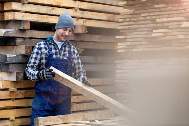 Young male worker in timber warehouse  - Φωτογραφία, εικόνα