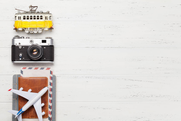 Travel concept with retro camera, airplane, passport and tram toy. Top view flat lay with copy space - Photo, Image