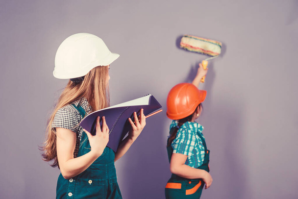 Sisters happy renovating home. Home improvement activities. Renovation team. Kids girls planning renovation. Repaint walls. Move in new apartment. Children sisters run renovation their room - 写真・画像