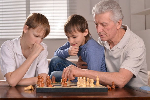 two boys and grandfather playing chess - Foto, immagini