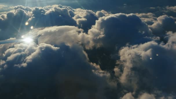 Luchtfoto boven wolken vanuit vliegtuigraam met blauwe lucht. zicht vanuit het vliegtuigraam naar de blauwe lucht en witte wolken. Reizen met het vliegtuig. - Video