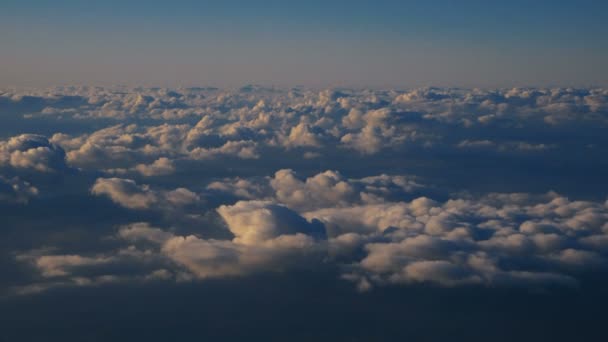 Luftaufnahme über Wolken aus dem Flugzeugfenster mit blauem Himmel. Blick aus dem Flugzeugfenster auf den blauen Himmel und die weißen Wolken. Reisen mit dem Flugzeug. - Filmmaterial, Video
