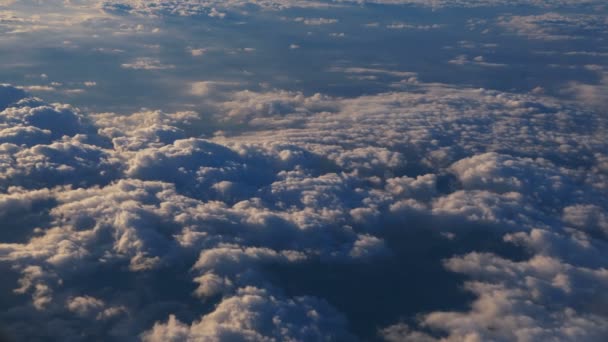 Mavi gökyüzü olan uçak penceresinden bulutların üstündeki hava manzarası. Uçak penceresinden mavi gökyüzüne ve beyaz bulutlara. Uçakla seyahat etmek.. - Video, Çekim