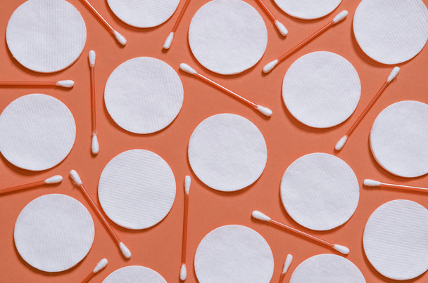 Средства гигиены: круглые белые хлопчатобумажные коврики и ватные тампоны на цветном фоне
 - Фото, изображение
