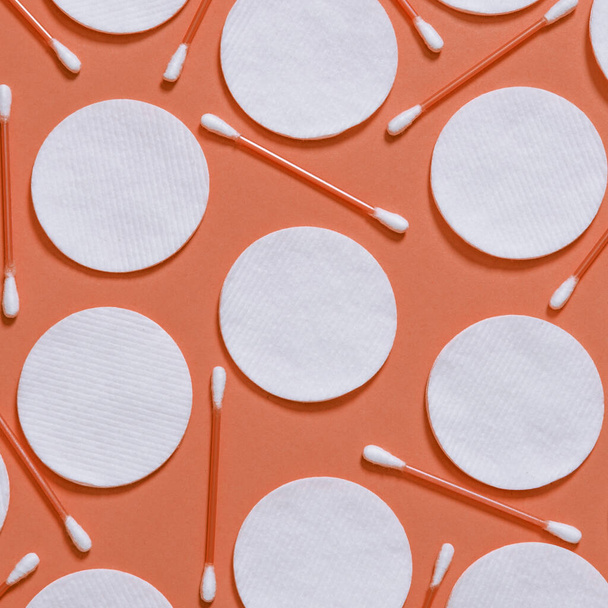 Hygiene products: round white cotton pads and cotton swabs are on colored background - 写真・画像