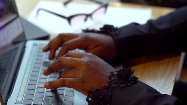 Amerykańska bizneswoman pracująca z laptopem i papierami. Zajęta kobieta płaci rachunki bankowość online zarządzanie finansami sprawdzanie budżetu robi papierkową robotę za pomocą komputera siedzi przy biurku - Materiał filmowy, wideo