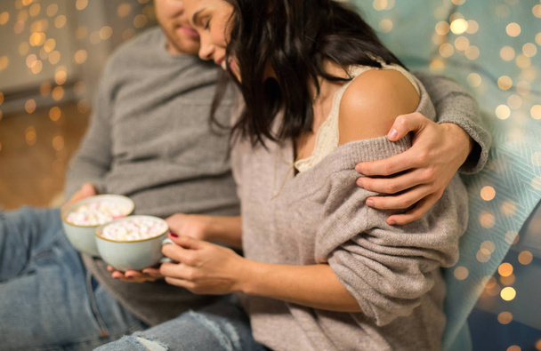 close up of couple with hot chocolate at home - Foto, imagen