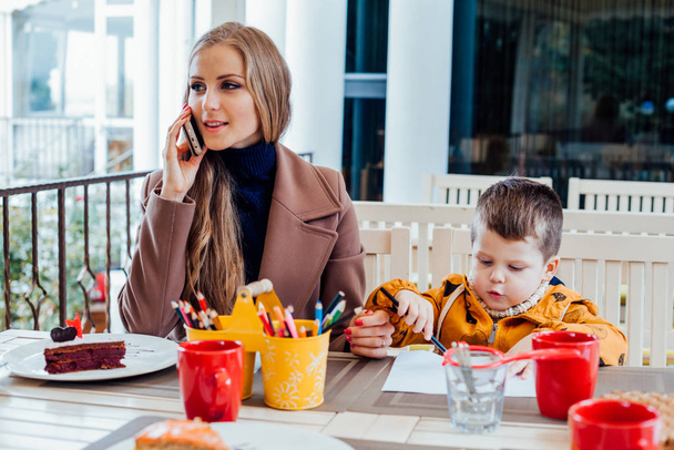 Restaurant maman avec fils parlant au téléphone
 - Photo, image