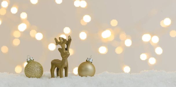 коллекция золотых рождественских предметов на белом снегу с сияющими огнями на заднем плане
 - Фото, изображение