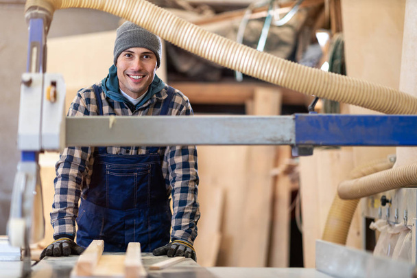 Joven trabajador masculino en almacén de madera
  - Foto, Imagen