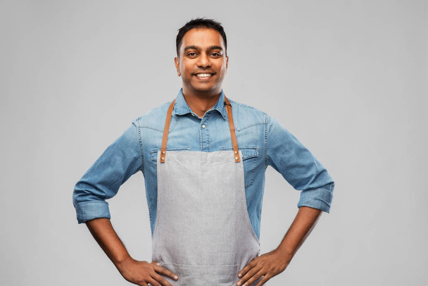 smiling indian barman, waiter or salesman in apron - Foto, imagen