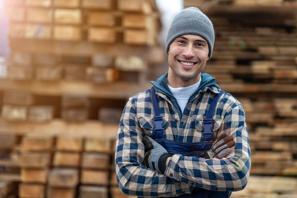 Jeune travailleur masculin dans un entrepôt de bois
  - Photo, image